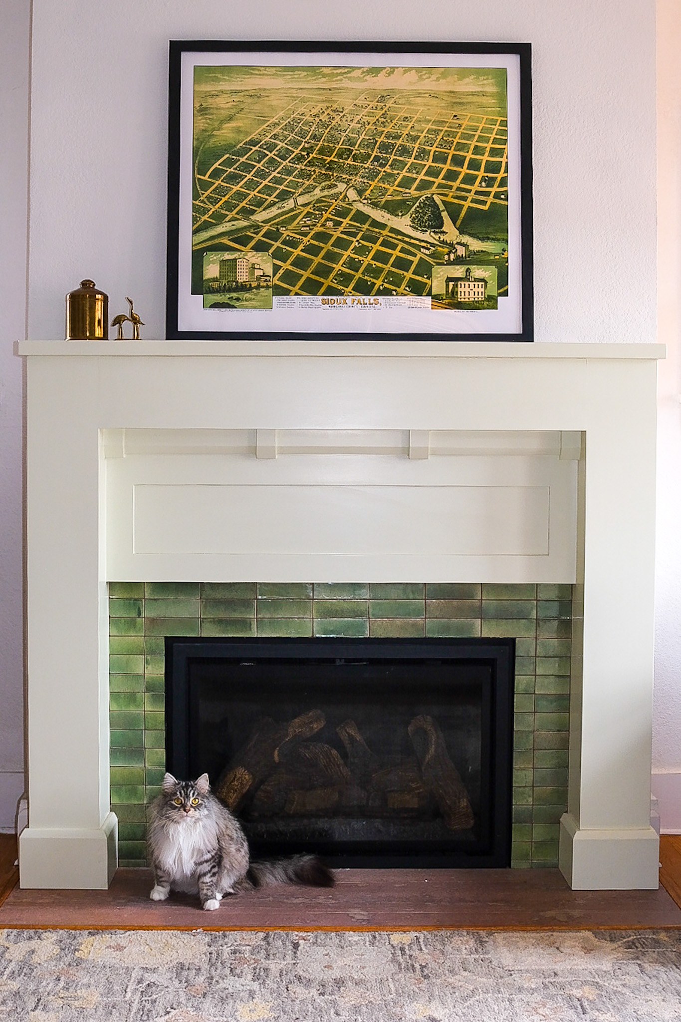 A white Craftsman fireplace with a green glazed subway tile surround