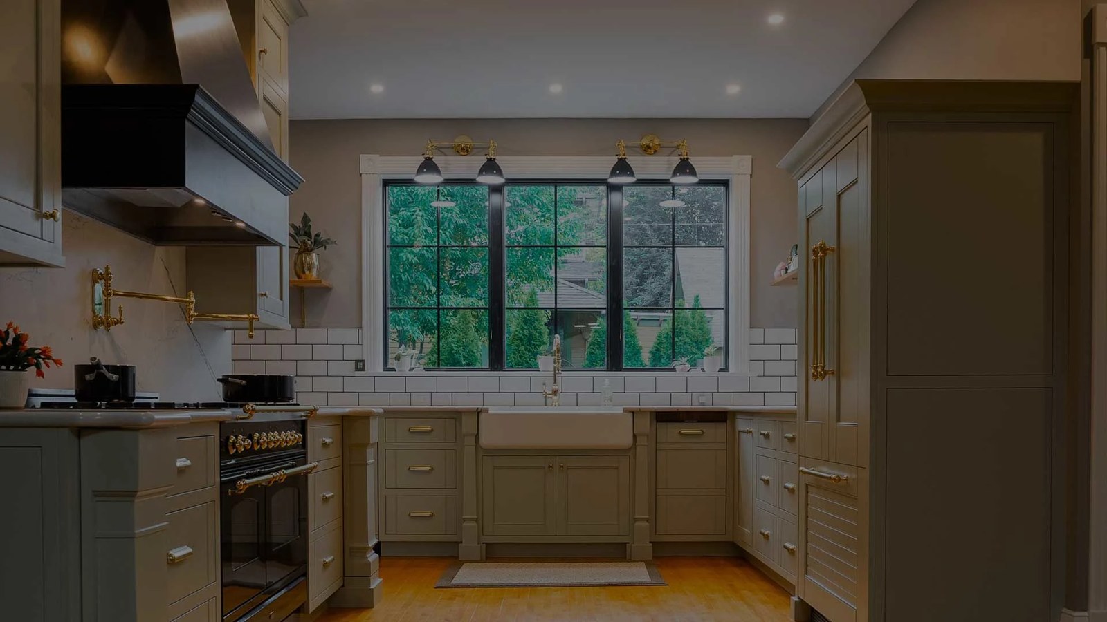 A kitchen remodel by Dwellings with sage cabinetry and a farmhouse sink